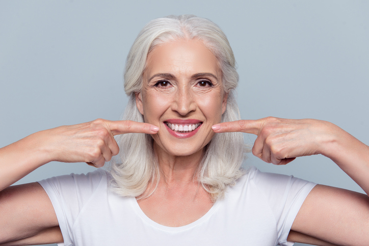 woman smiling because she replaced missing teeth